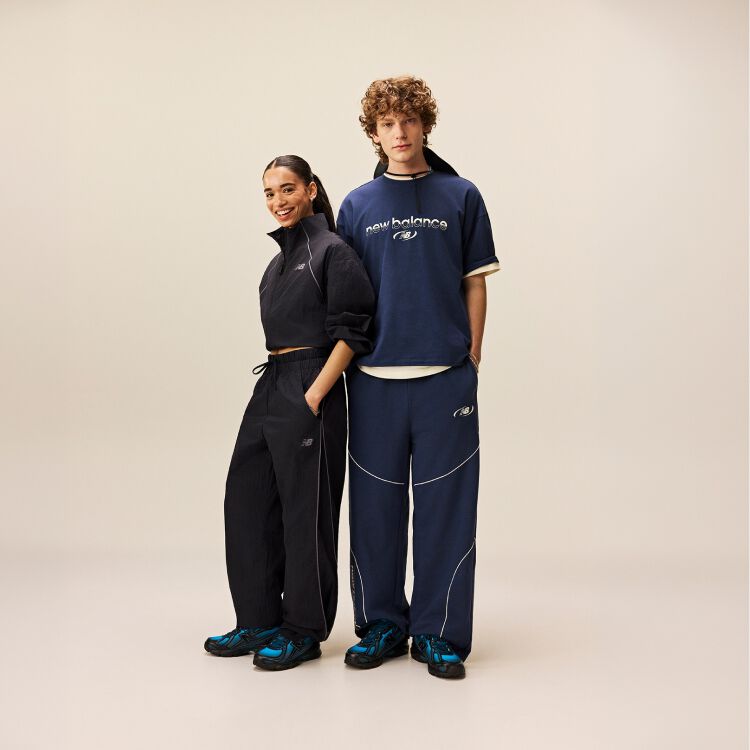  Man sitting down while woman is standing with her arm rested on his shoulder.